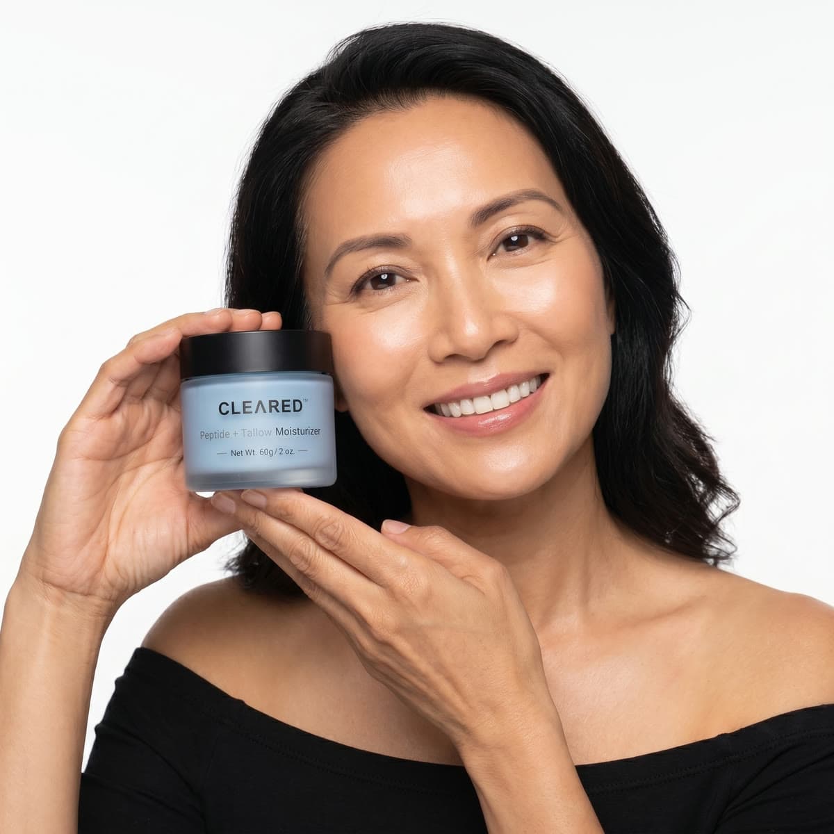A woman holding the CLEARED jar beside her face